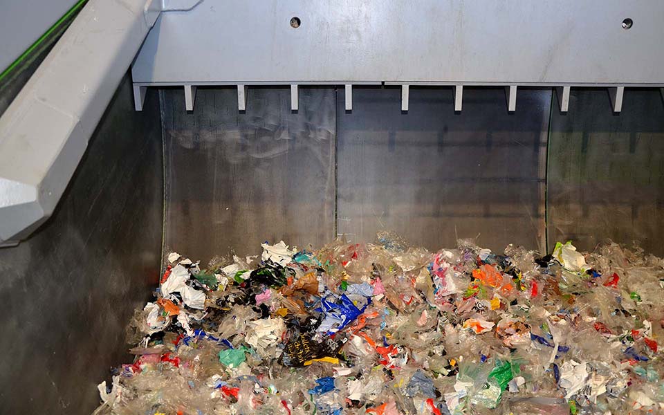 A rocking system with hydraulic pusher presses the waste against the rotating rotor.